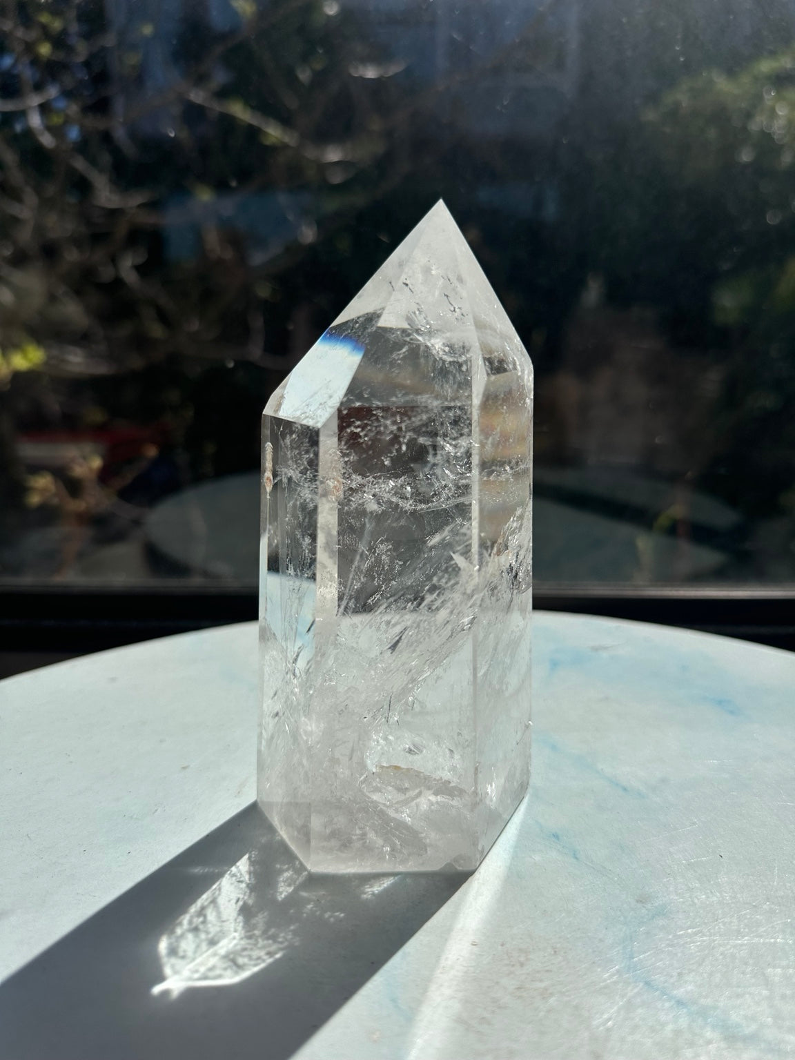 Alternate side of the Brazilian quartz tower with transparent upper areas, layered internal veils and reflections along the point.