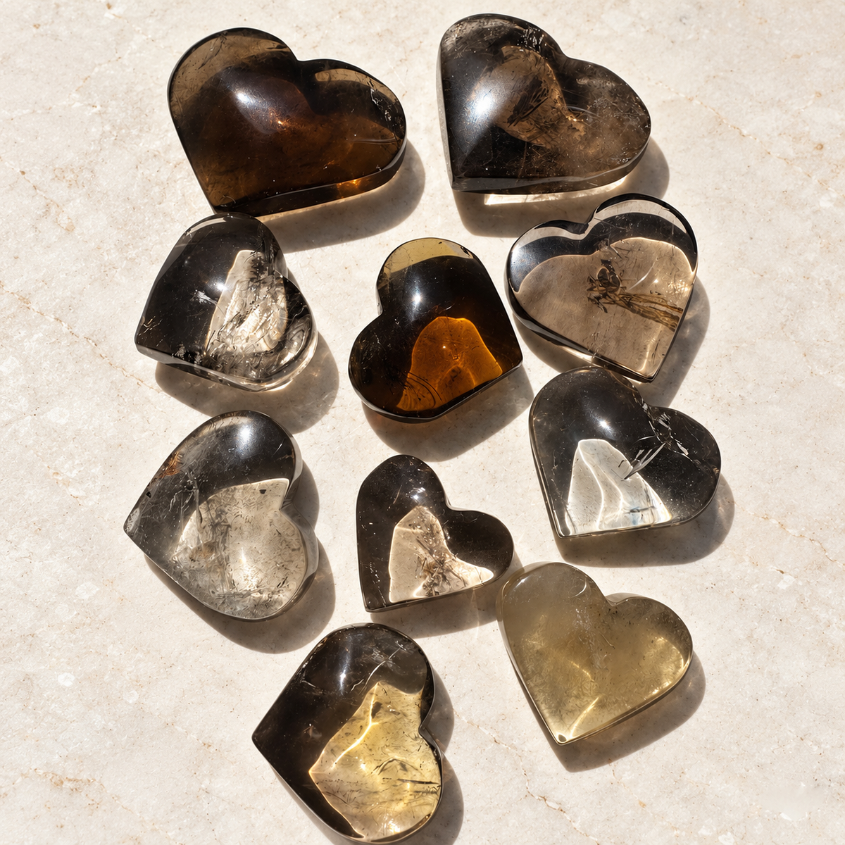 Overhead view of polished smoky quartz hearts with varied smoky and tea-brown tones