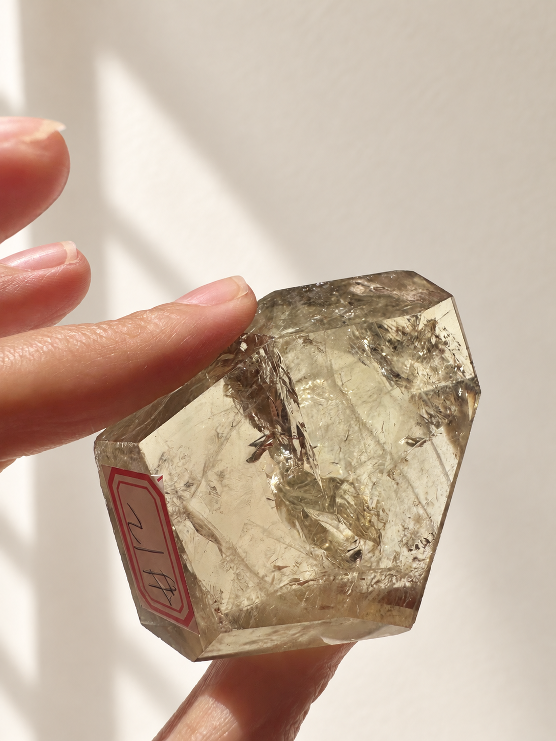 Natural Brazilian citrine 118g exact piece #12 view 11 in soft natural daylight against warm ivory wall