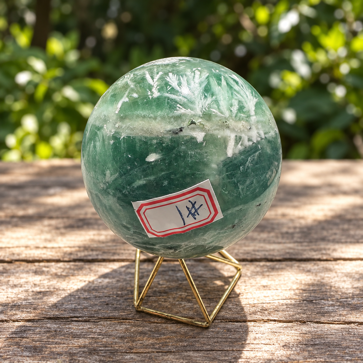 Front angle of No.1 fluorite sphere showing a broad pale band, dark green zoning and identification label