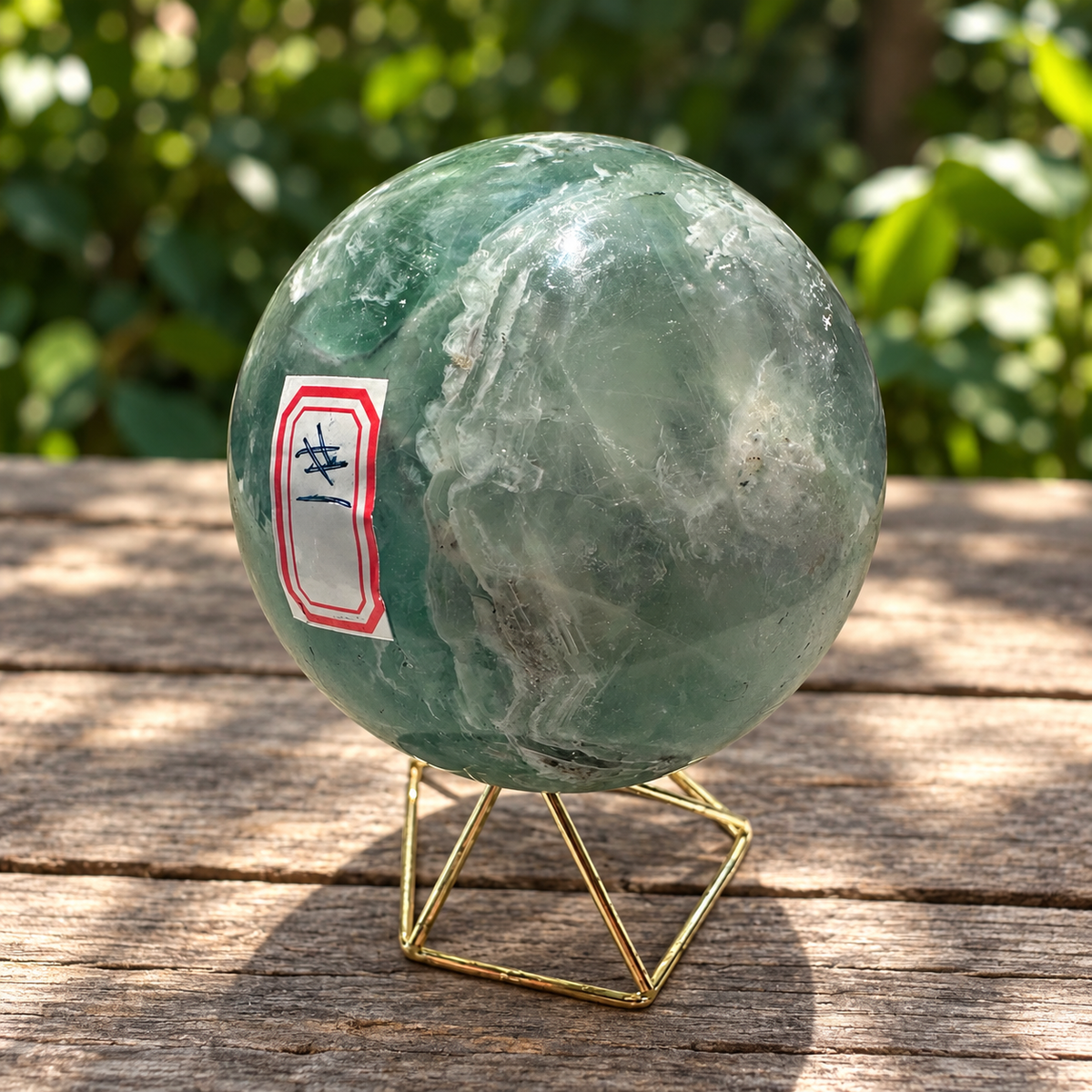 Reverse of feather fluorite sphere showing a cloudy pale area, internal lines and natural dark flecks
