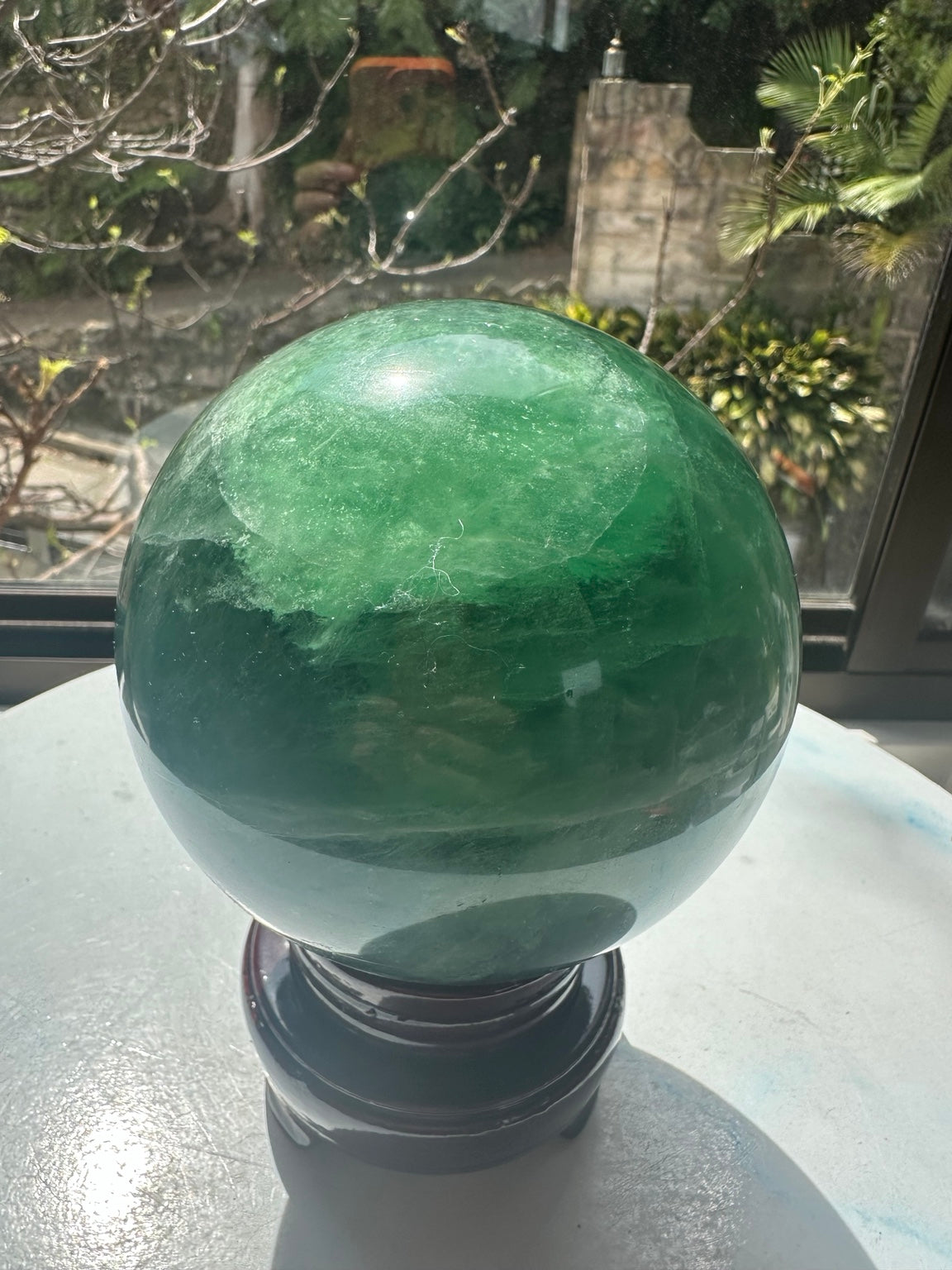Madagascar green fluorite sphere 11.5 cm on included wooden display stand, front view