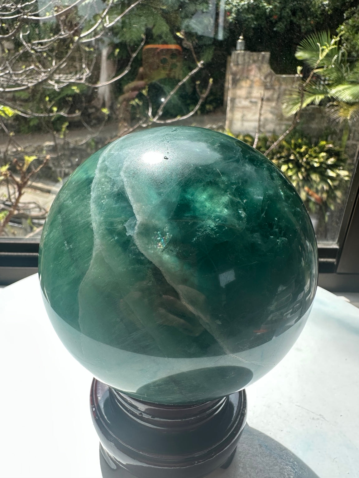Side of 2.71 kg Madagascar green fluorite crystal ball with pale internal band