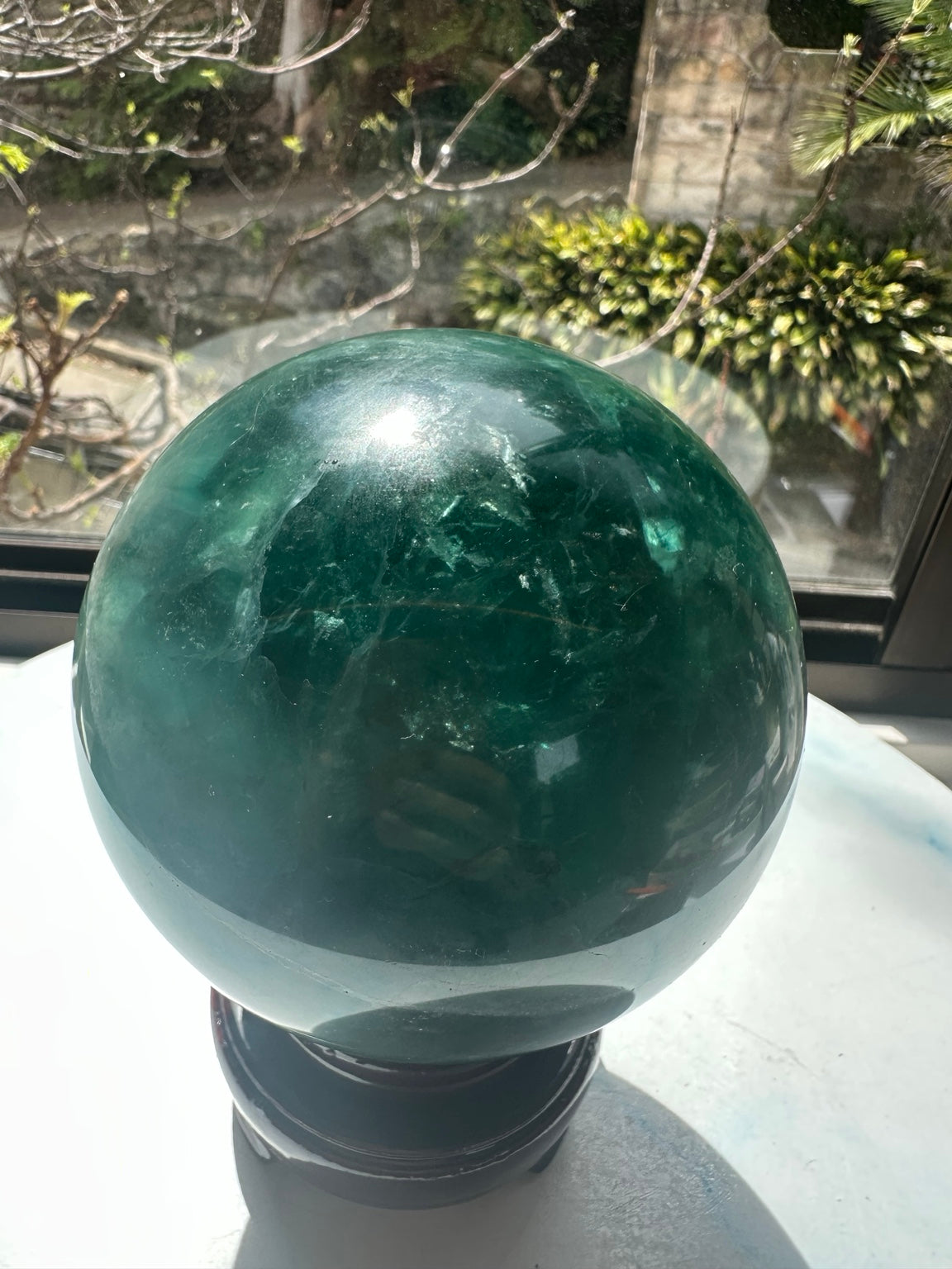 Dark green side of polished fluorite sphere with natural inclusions