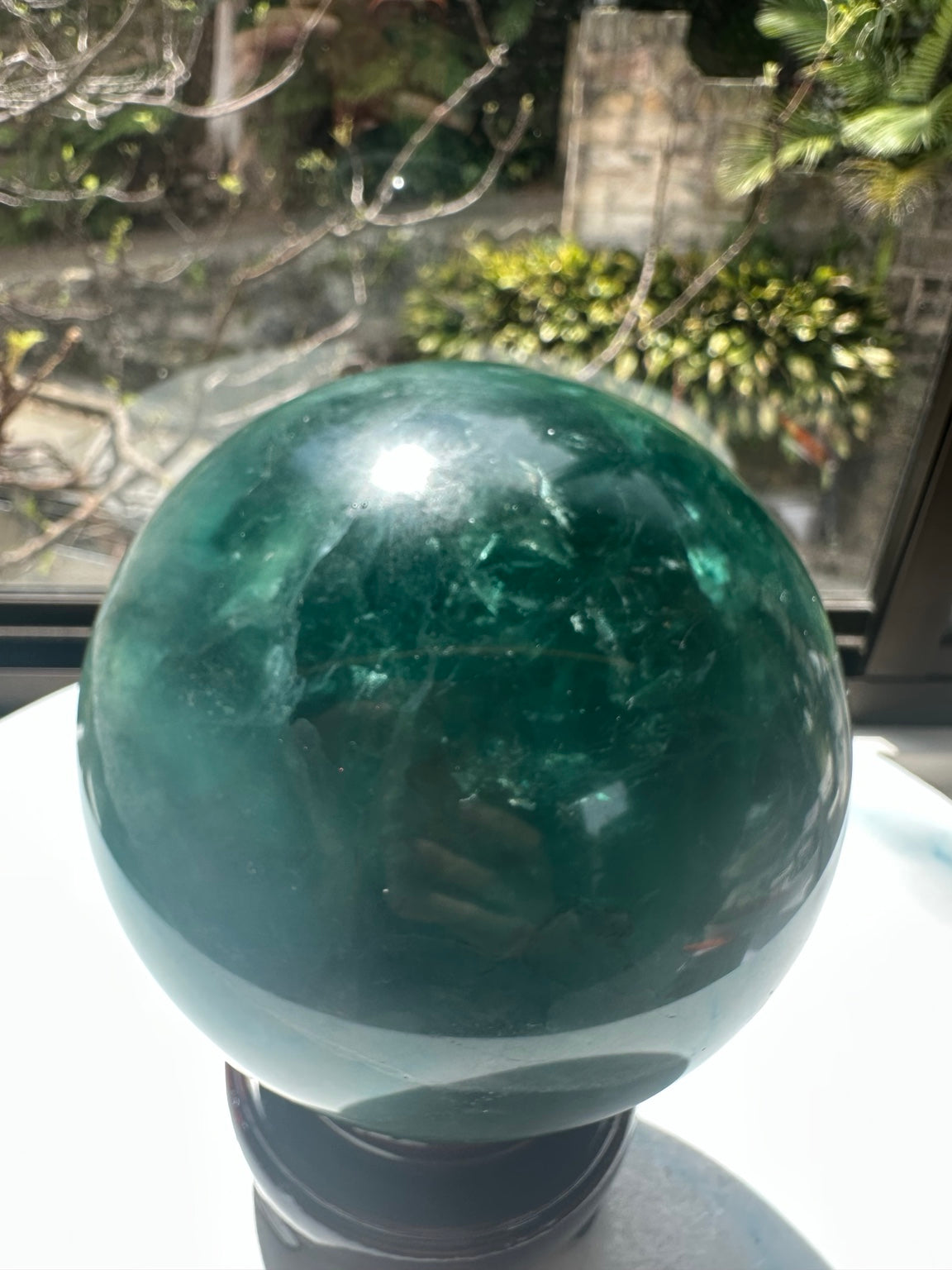 Detailed deep green fluorite sphere surface in sunlight