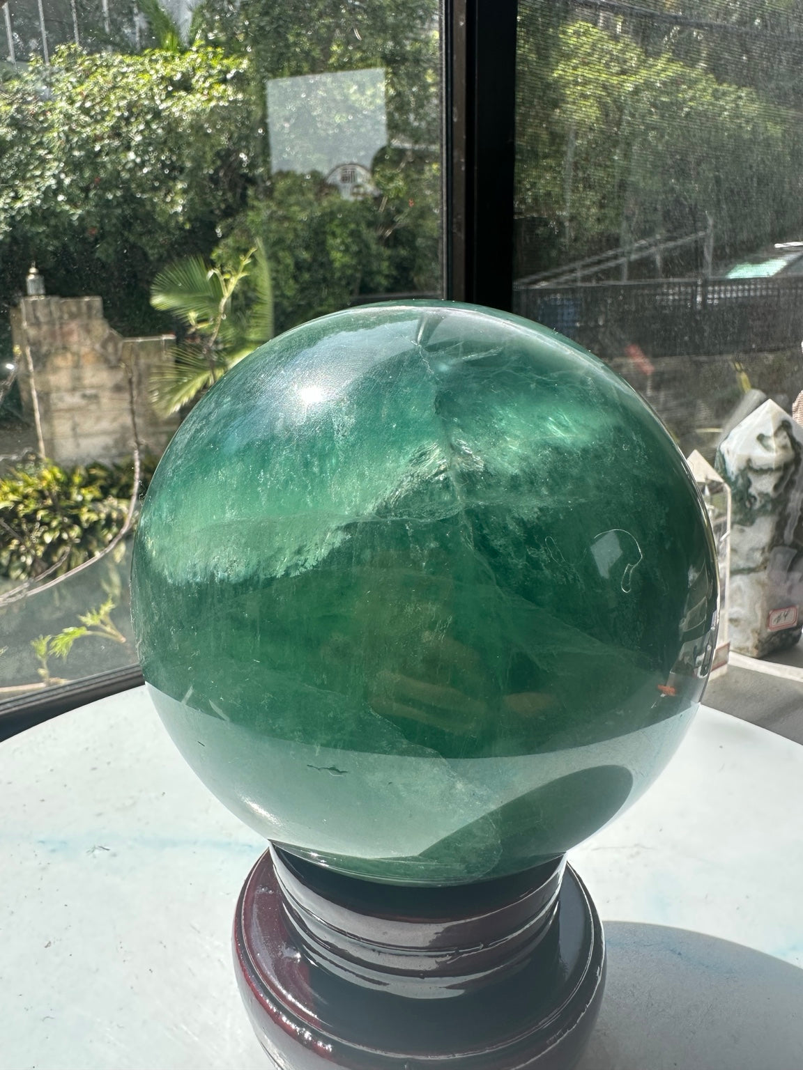 Exact 2.71 kg green fluorite sphere with colour zoning and wooden stand