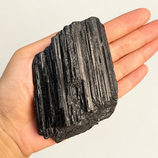 Raw black tourmaline in soft indoor light.