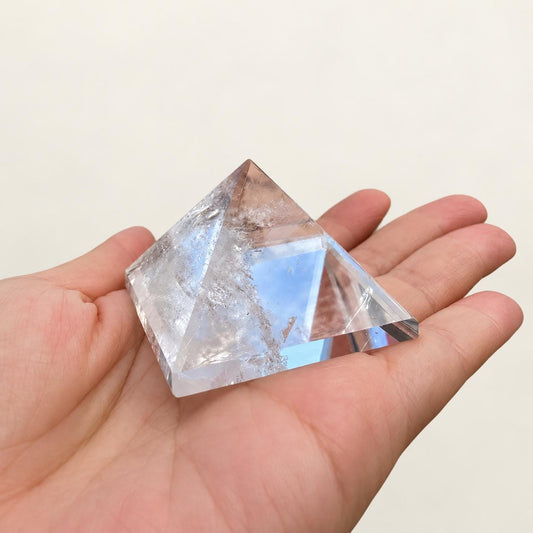 Clear quartz pyramid in soft indoor light.