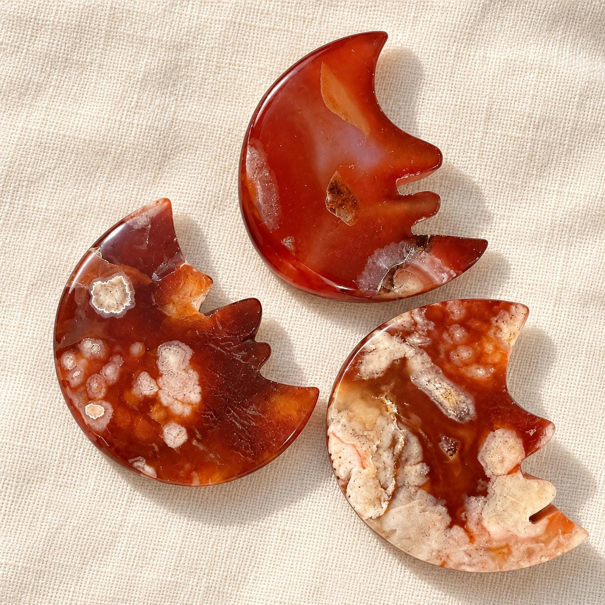Red agate smiling crescent moon crystal carving with natural white and orange patterns