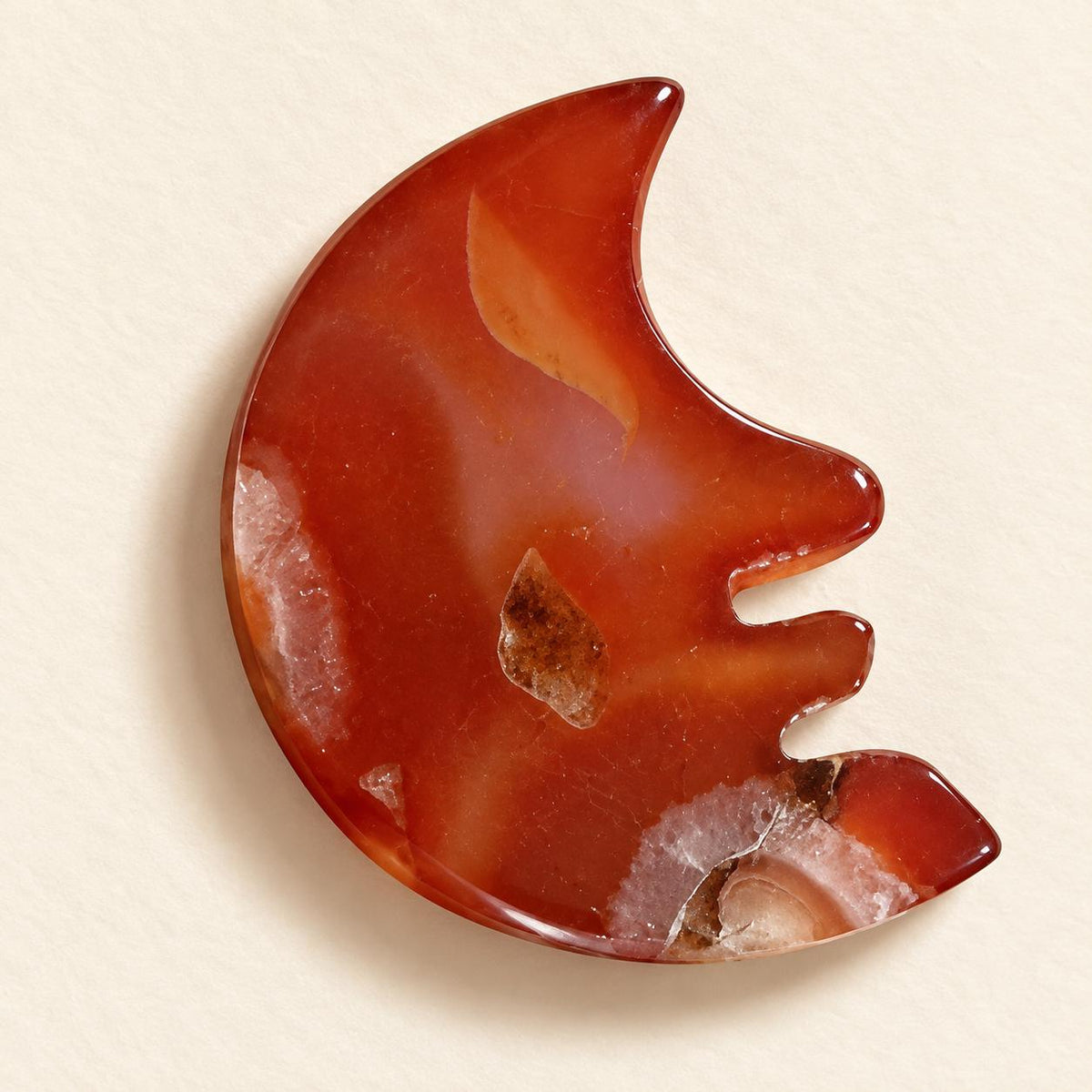 Natural red agate crescent moon pocket stone showing unique banding and inclusions