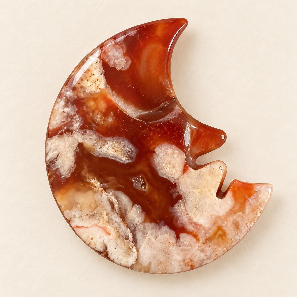 Smiling crescent moon crystal face carving in polished red agate