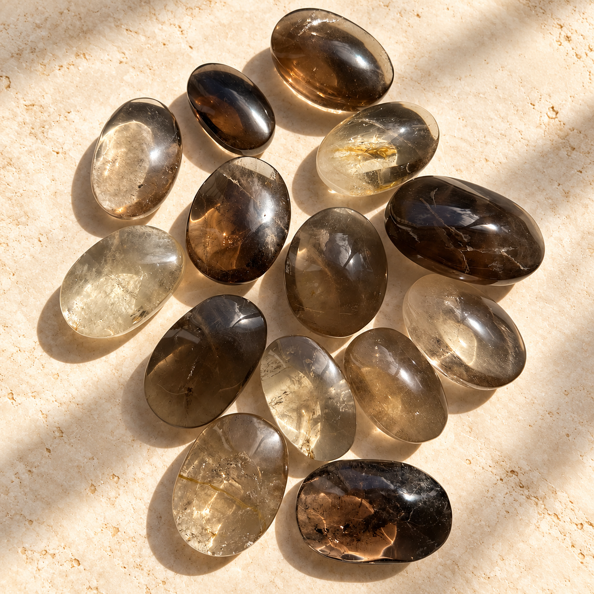 Polished smoky quartz palm stones showing light smoky and deep brown colours with natural inclusions