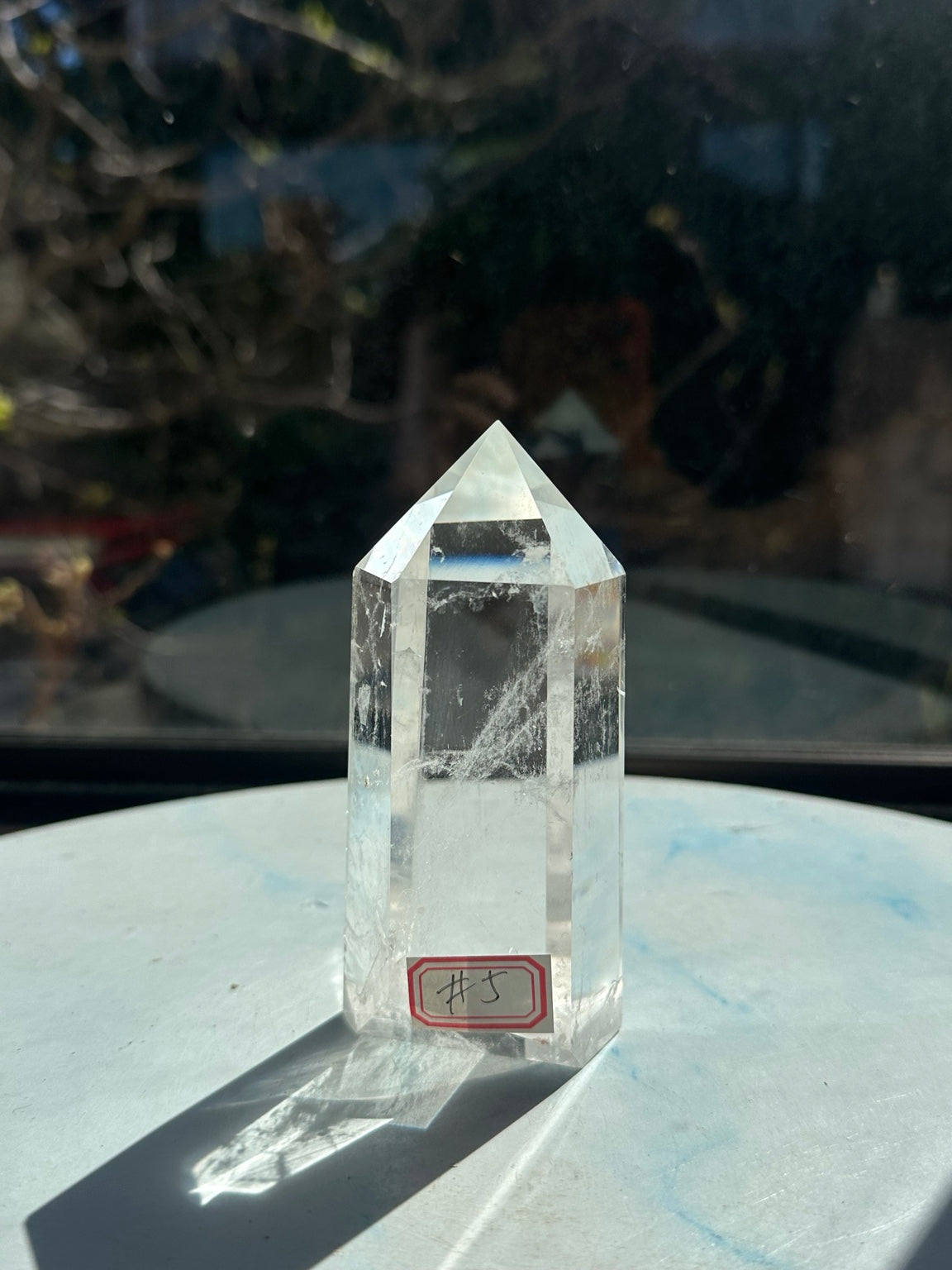Front view of clear quartz tower #5 showing transparent body, white veils and flat base