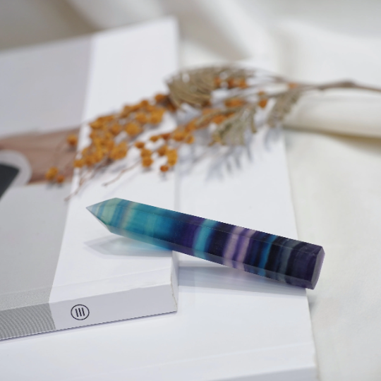 Rainbow Fluorite crystal point showing polished tower shape and banding